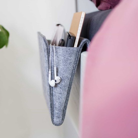 Grijze vilten nachtkastje opberger met oortjes die uit een vakje hangen.