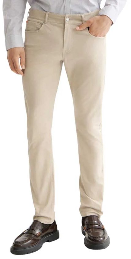 Man in beige corduroy broek, voorkant, met licht gestreepte blouse en bruine schoenen.