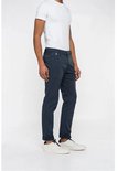 Man met donkerblauwe chino broek, omgeslagen broekspijpen en witte sneakers, zijaanzicht.