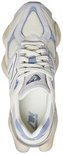Bovenkant van een lichtgrijze New Balance 9060 sneaker met beige en lichtblauwe details, veters en een witte binnenzool.