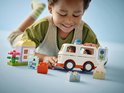 Kind speelt met LEGO Duplo ambulance, met ziekenhuisje, bloemen, doktersfiguur en patiënt in bed.