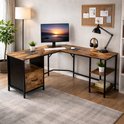 L-vormig hoekbureau met roodbruin houtlook blad, een lade en drie open vakken, ingericht met computer en accessoires.