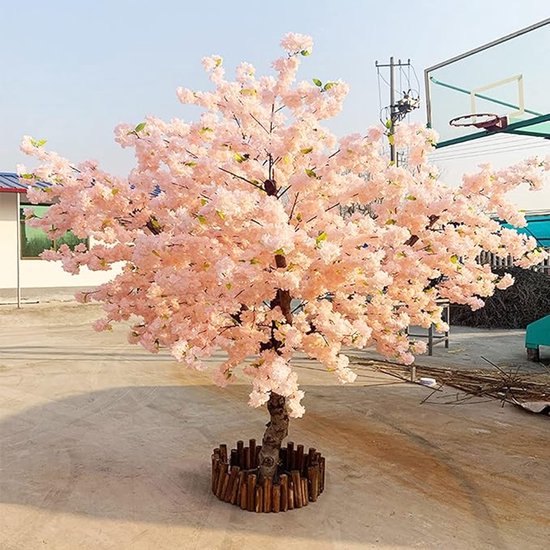Arbre artificiel de cerisier en fleurs aux fleurs roses épanouies et un tronc naturel, dans une jardinière en bois.
