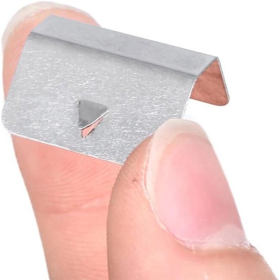 Close-up van een zilverkleurige metalen klem, U-vormig met inkeping, vastgehouden tussen vingers.