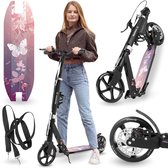 Zwarte opvouwbare step met een roze en paarse bloemen- en vlinderprint, staand naast een vrouw en een losse step-dek.