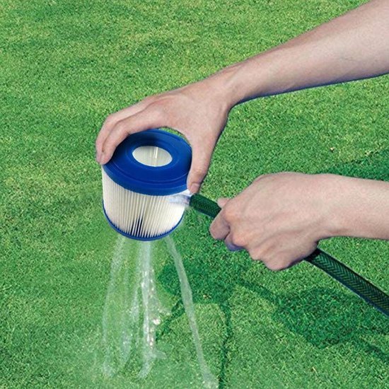 Een hand spoelt een Intex S1 zwembadfilter met een tuinslang op een groen gazon.