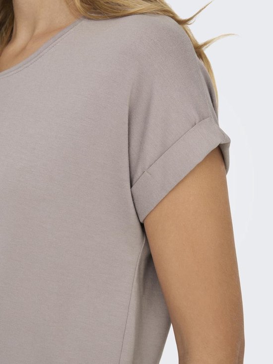 Close-up van de omgeslagen korte mouw van een lichtbruin T-shirt.
