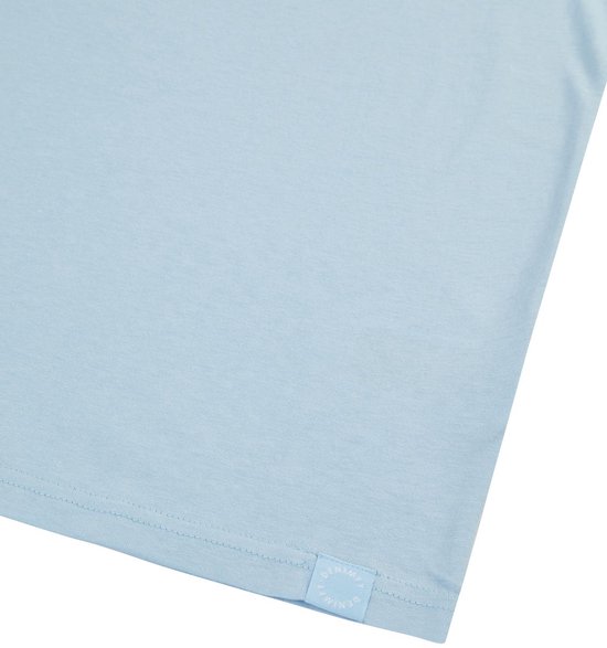 Detail van een effen lichtblauwe top met een klein blauw logo-label op de zoom.