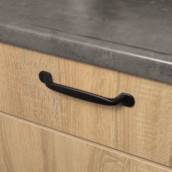 Zwarte handgreep op een houten lade.