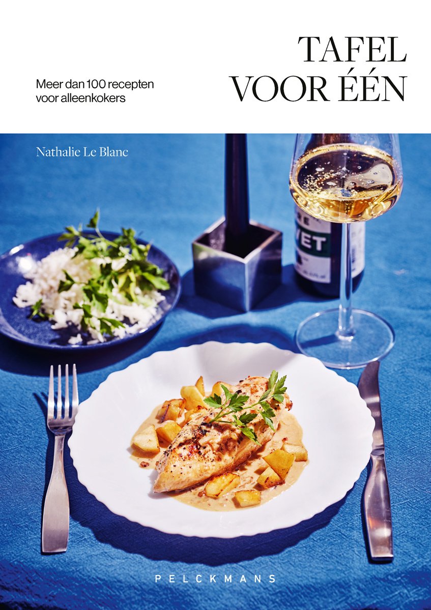 Een gedekte tafel met een bord kip met aardappelen, salade en een glas witte wijn.