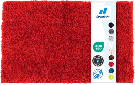 Donkerrode, pluizige badmat met een zachte textuur. Label met 'OEKO-TEX' en 'MACHINE WASHABLE'.