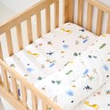 Houten ledikant opgemaakt met beddengoed met safari print van giraffen, olifanten, zebra's, krokodillen en apen.