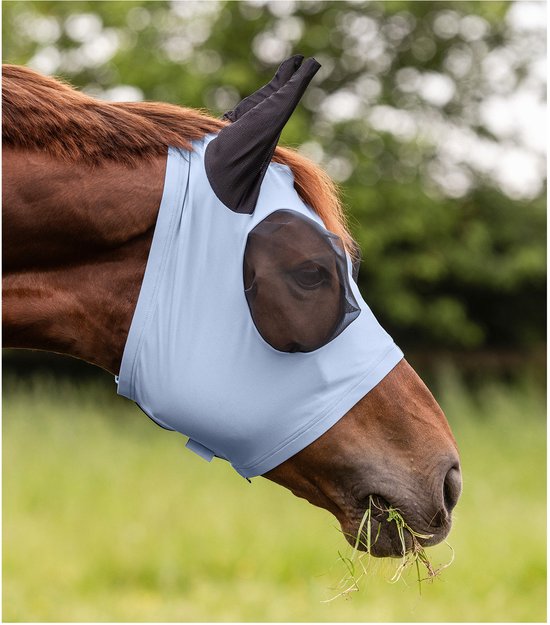 Lichtblauw vliegenmasker met zwarte oren en netstof rond de ogen. Paard met bruine vacht eet gras.