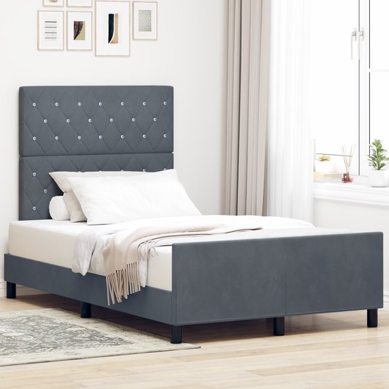 Donkergrijs fluwelen bed opgemaakt met wit beddengoed in een slaapkamer.