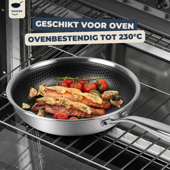 Koekenpan met honingraatpatroon, gevuld met zalm, courgette en tomaten, staat in een oven.