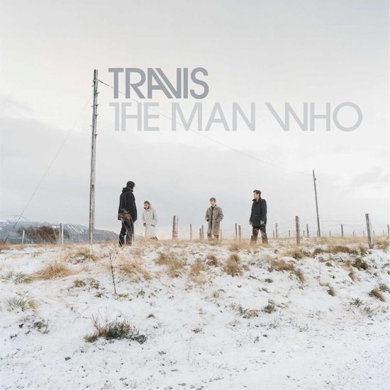 Vier mannen met winterjassen staan op een besneeuwde heuvel bij een hek. Travis - The Man Who.