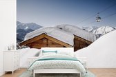 Behang - Fotobehang Sneeuw op een hut in Zwitserland - Breedte 450 cm x hoogte 300 cm