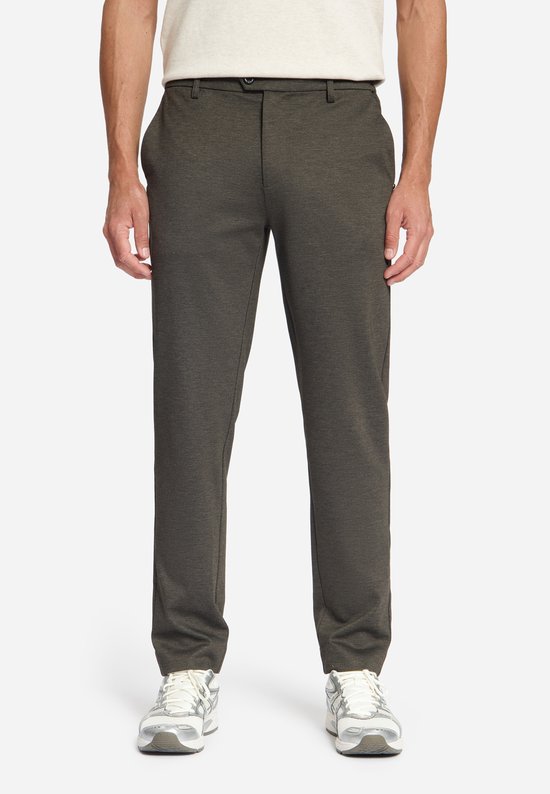 Man die een donkerbruine jersey pantalon draagt met een licht beige trui.