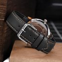 Bracelet de montre en cuir de veau noir avec coutures beiges, boucle argentée, attaché à une montre.