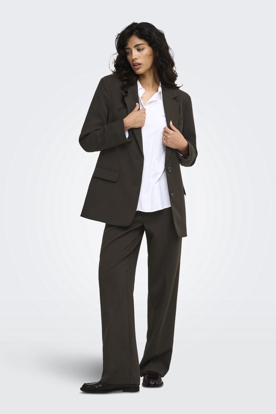 Model draagt een donkerbruine blazer en pantalon met een wit overhemd.
