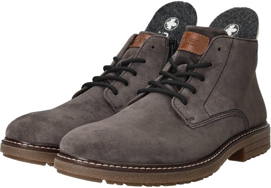 Grijze suède Rieker veterboots met zwarte veters en een bruine zool. De binnenzijde toont een grijs met zwarte inlegzool.