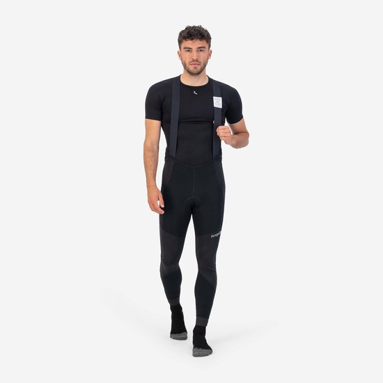 Man met zwarte fietsbroek met bretels en zwart T-shirt, met Rogelli logo op de broek.