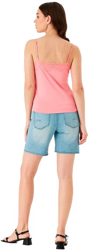 Model van achteren gezien, draagt een roze kanten top en spijkerbroek met korte broek
