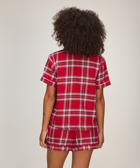 Model op de rug gezien in een rode pyjamaset met ruitpatroon.