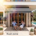 Grijze zonneluifel boven een terras met een koppel dat koffie drinkt. Beschrijft de luifel als een 'Rust-zone'.