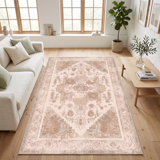 Een terracotta medaillon vloerkleed op een houten vloer in een lichte woonkamer met een bank.