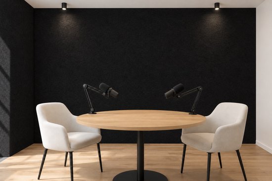 Podcast-studio met zwarte viltwanden, een ronde houten tafel en twee witte fauteuils met microfoons op armen.