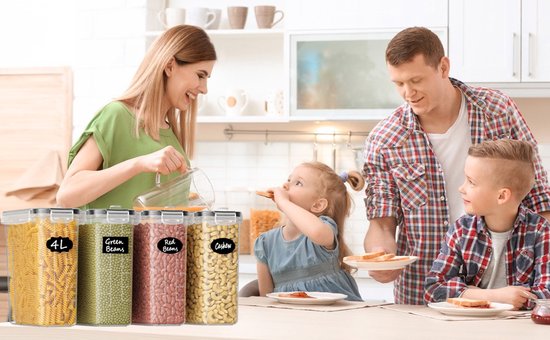 Een gezin van vier in de keuken, met op de voorgrond vier voorraadcontainers gevuld met pasta, groene bonen, rode bonen en cashewnoten.