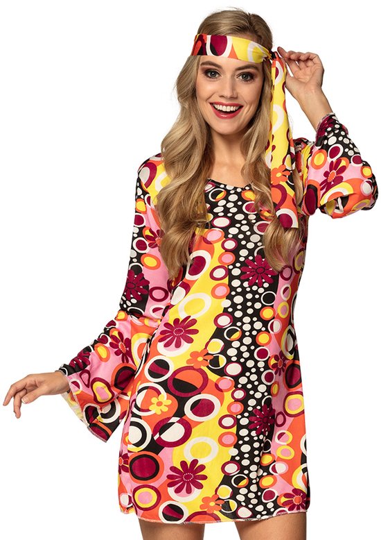 Femme dans une robe hippie colorée à manches évasées, motif floral et circulaire, avec bandeau assorti.