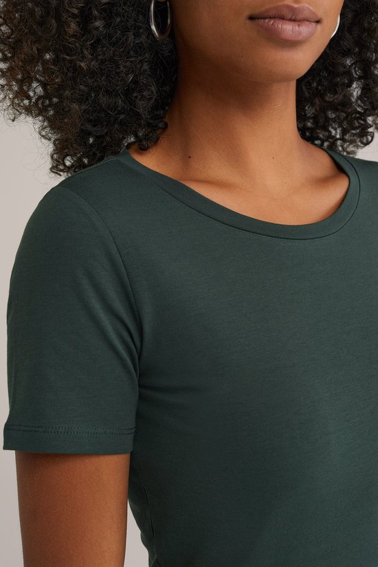 Close-up van een donkergroen t-shirt met ronde hals en korte mouwen.