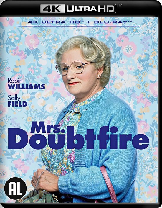 Robin Williams en Mrs. Doubtfire, portant un cardigan bleu tricoté, une chemise à fleurs et des lunettes. "Mrs. Doubtfire" en bleu est mis en évidence.
