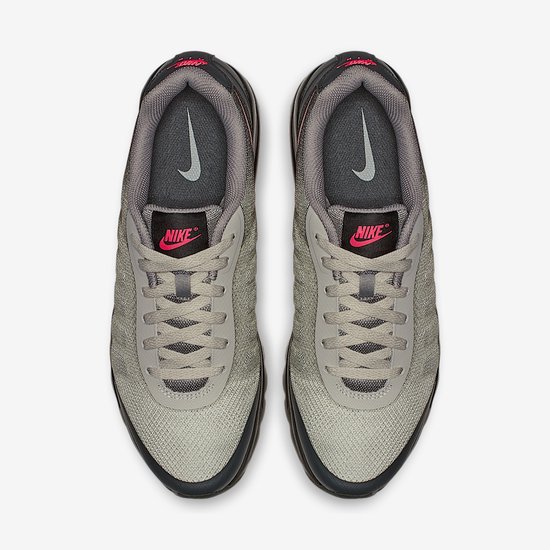 Bovenaanzicht van grijze Nike sneakers met roze Nike logo op de tong en grijze veters.