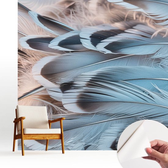 Zelfklevend fotobehang met blauwe veren, een fauteuil met houten frame en een hand die de zelfklevende laag toont.