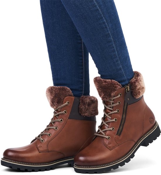 Bruine leren veterboots met imitatiebont gedragen met een blauwe spijkerbroek.