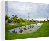 Canvas schilderij 180x120 cm - Wanddecoratie Water van een kanaal in Paramaribo, Suriname - Muurdecoratie woonkamer - Slaapkamer decoratie - Kamer accessoires - Schilderijen