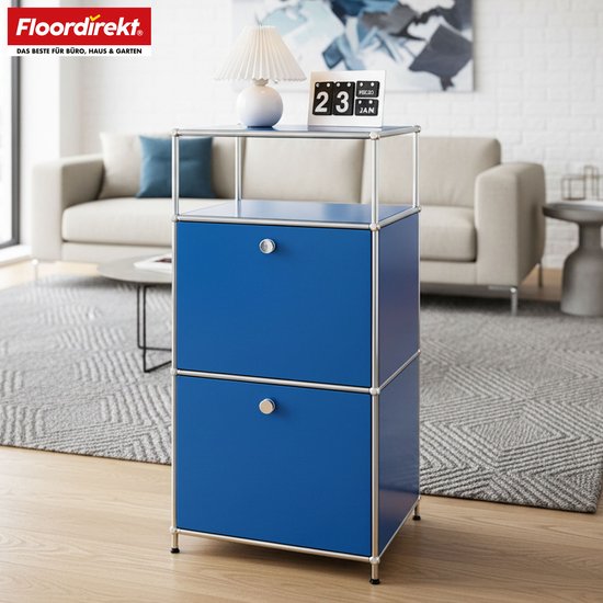 Blauw opbergrek met twee laden, een open vak en een legplank, bij een bank met kussens in een woonkamer.
