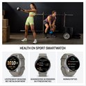 Twee sporters in een gym. Een vrouw doet kettlebell swings, een man doet een kettlebell lift. De smartwatches tonen gezondheids- en sportgegevens.