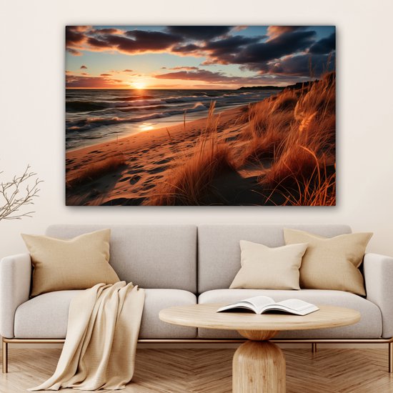 Une toile d'un coucher de soleil sur la mer et la plage, dans un salon avec canapé.