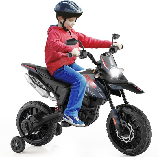 Jongen in rode hoodie en blauwe jeans rijdt op een zwarte elektrische Aprilia kinder-motorfiets met steunwielen.