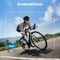 Een fietser rijdt op een racefiets op een weg, met een landschap op de achtergrond. Beeldstabilisatie is ingeschakeld.