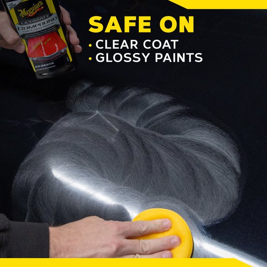 Hand houdt fles Meguiar's Ultimate Compound vast boven een glanzende zwarte auto waar met een gele applicator op wordt gewreven.