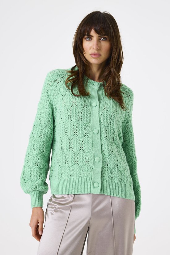 Veste verte à motif torsadé et manches ballon, portée par une mannequin.