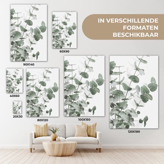 Canvas van eucalyptusbladeren in verschillende formaten boven een bank.
