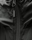 Ritsdetail met een "WEEKEND" label op de kraag van een donkergrijze jas.