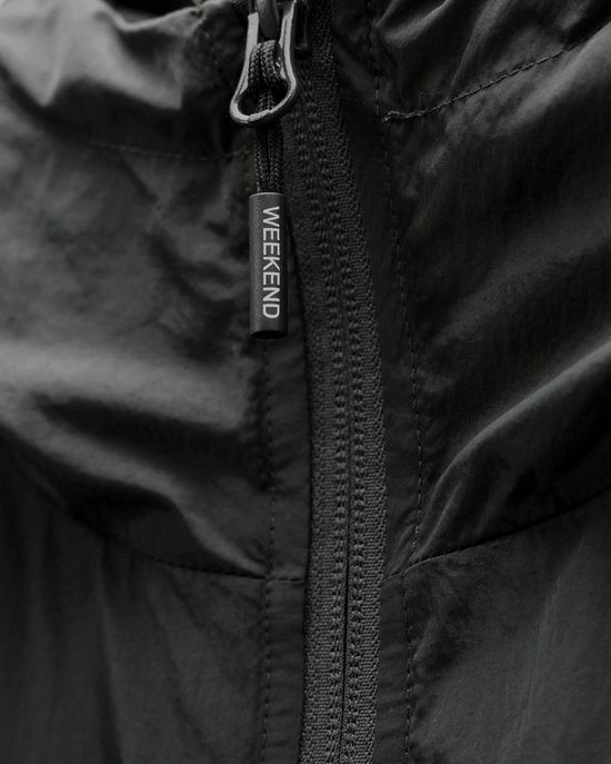 Ritsdetail met een "WEEKEND" label op de kraag van een donkergrijze jas.