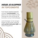Bamboe matcha klopper in een grijze glazen houder. De houder is kelkvormig en breed aan de voet.